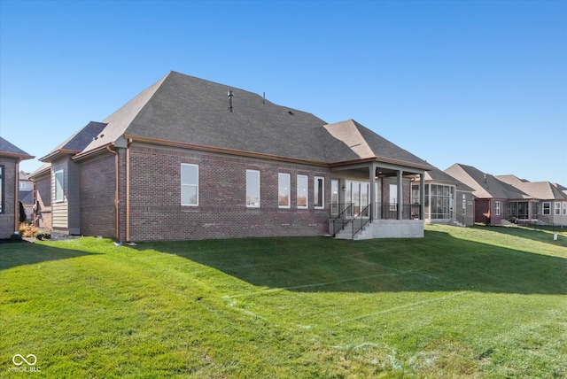 back of house with a yard and a sunroom