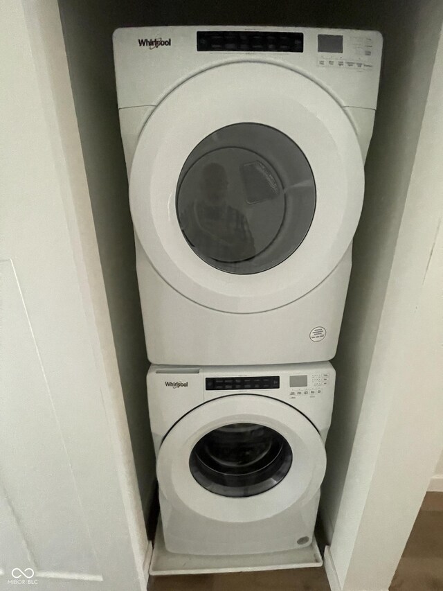 clothes washing area featuring stacked washer and clothes dryer