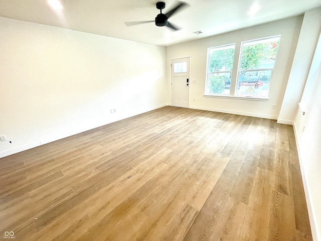 empty room with ceiling fan and light wood-type flooring