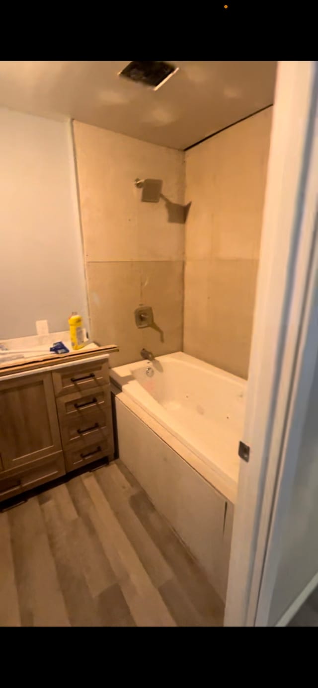 bathroom featuring tiled shower / bath combo and hardwood / wood-style floors