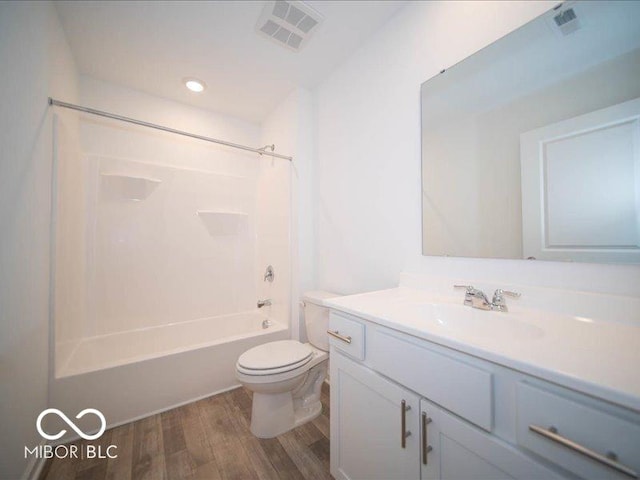 full bathroom featuring hardwood / wood-style flooring, vanity, toilet, and washtub / shower combination