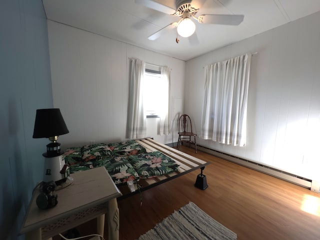 bedroom with light hardwood / wood-style flooring, ceiling fan, and baseboard heating