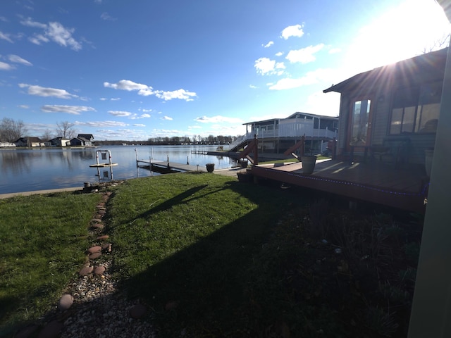 view of yard with a water view and a dock