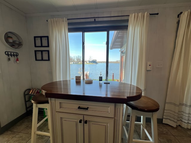 interior space with tile floors and a water view