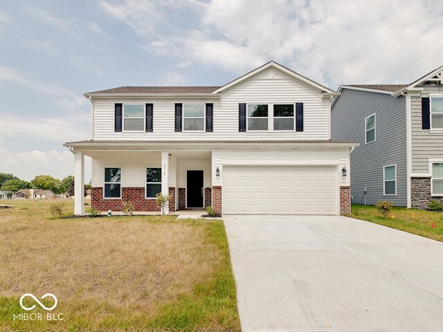 view of front of home with a garage, a front yard, and a porch