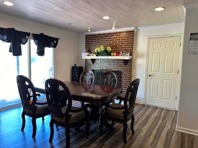 dining room with a brick fireplace, crown molding, and hardwood / wood-style flooring