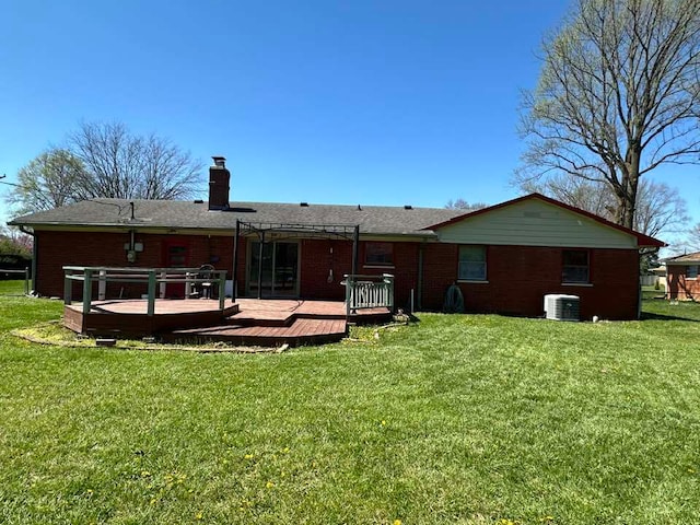 rear view of property featuring a deck, central AC unit, and a yard