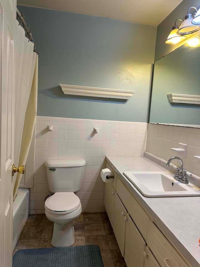 full bathroom with tile walls, large vanity, and tile floors