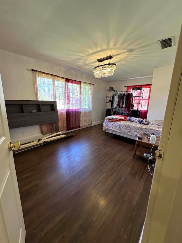 bedroom with an inviting chandelier and dark hardwood / wood-style floors