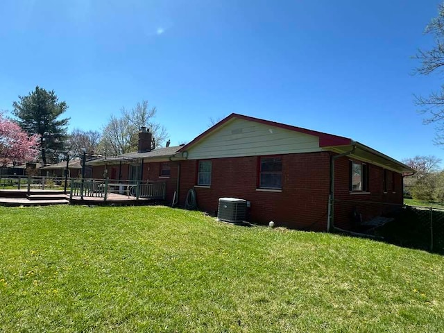 view of home's exterior featuring a deck, central AC unit, and a lawn