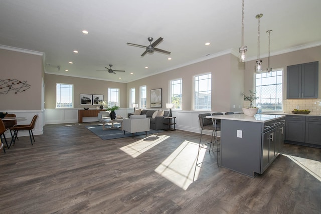 kitchen featuring dark hardwood / wood-style floors, gray cabinets, a breakfast bar area, and a kitchen island