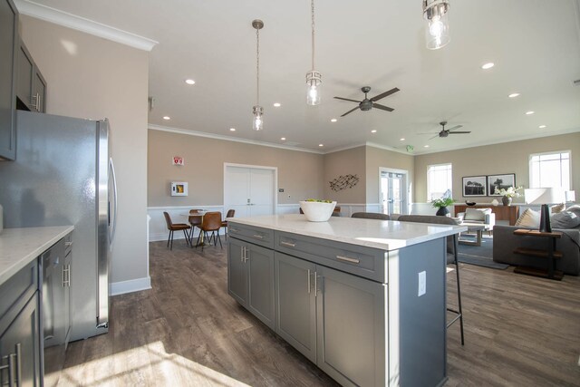 kitchen featuring a breakfast bar, hanging light fixtures, dark hardwood / wood-style floors, and gray cabinets