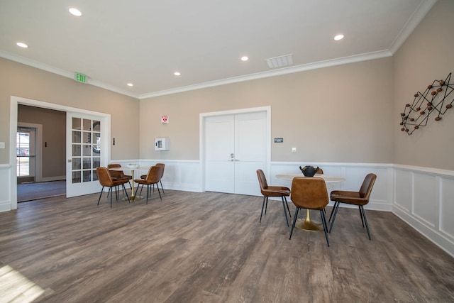 dining space with dark wood-type flooring, crown molding, and french doors