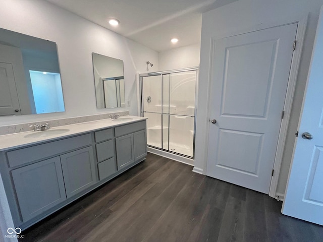 bathroom with hardwood / wood-style floors, walk in shower, and vanity