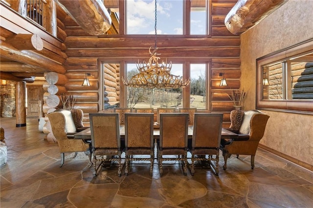 interior space featuring a chandelier, log walls, and a towering ceiling