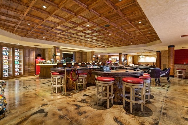 dining area featuring a raised ceiling and indoor bar