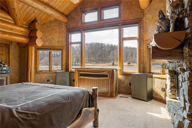 carpeted bedroom with wood ceiling, beam ceiling, high vaulted ceiling, and a stone fireplace