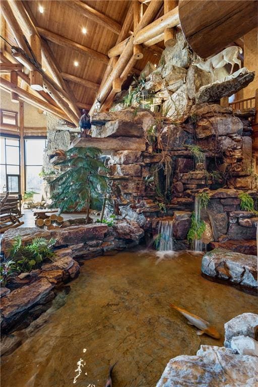 misc room with beamed ceiling, wooden ceiling, high vaulted ceiling, and rustic walls