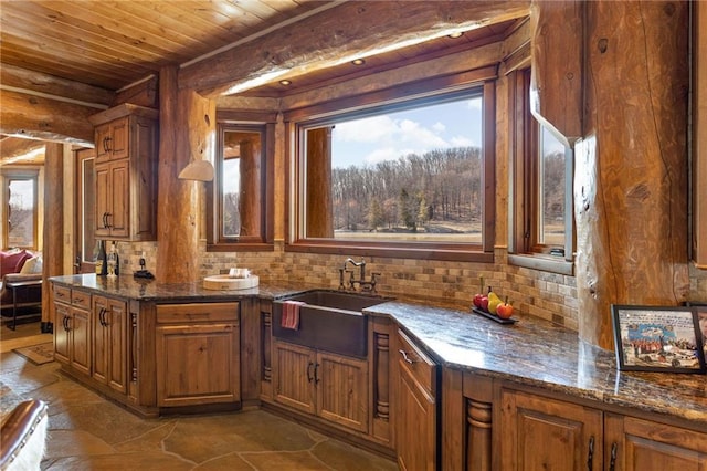 interior space with sink, wood ceiling, tasteful backsplash, dark stone countertops, and dark tile flooring