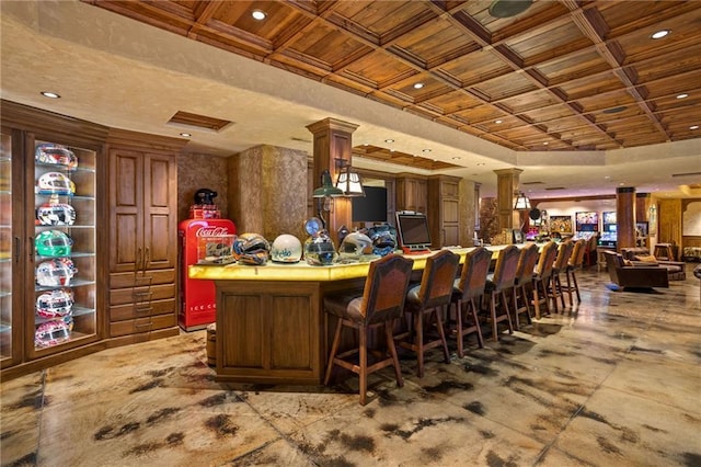 bar featuring ornate columns and coffered ceiling