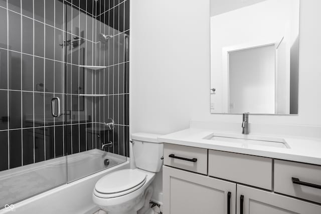 full bathroom with combined bath / shower with glass door, vanity, and toilet