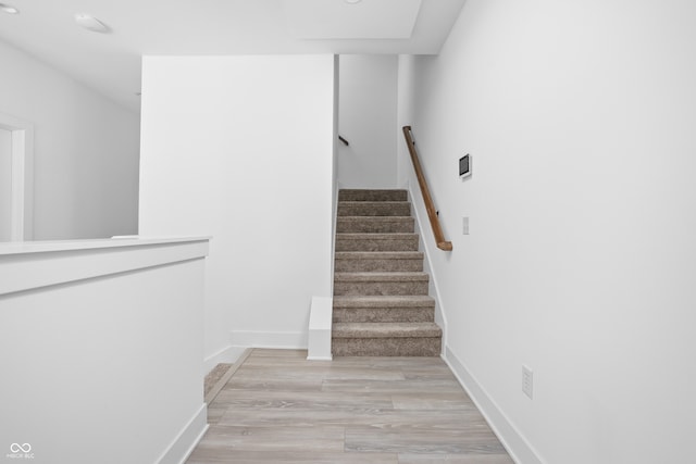 staircase with hardwood / wood-style floors