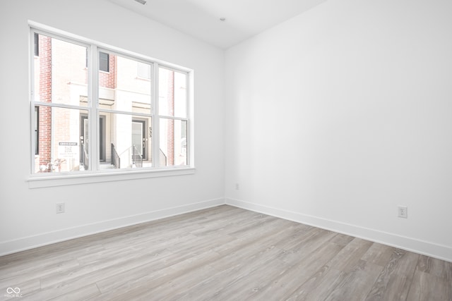 unfurnished room with plenty of natural light and light hardwood / wood-style flooring