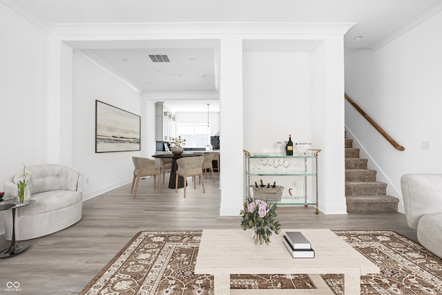 living room with ornamental molding and hardwood / wood-style flooring