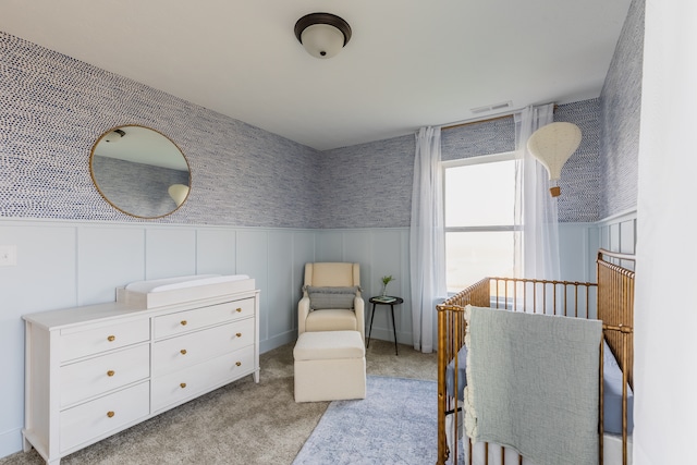 carpeted bedroom featuring a crib