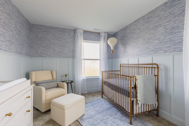 carpeted bedroom featuring a crib