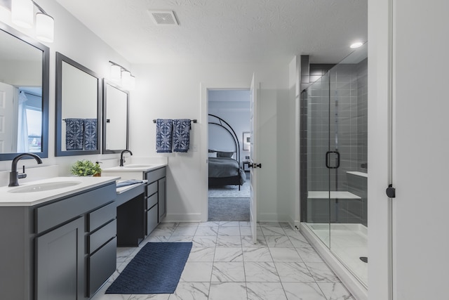 bathroom featuring a textured ceiling, a shower with shower door, dual bowl vanity, and tile flooring