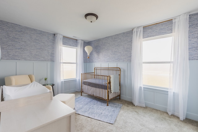 carpeted bedroom featuring a crib