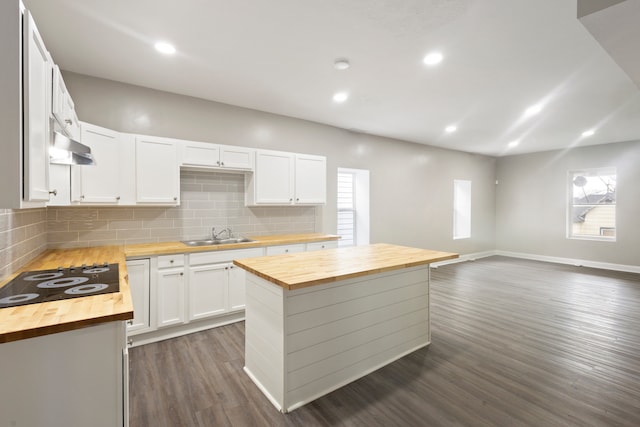 kitchen with butcher block counters, backsplash, dark hardwood / wood-style floors, white cabinetry, and a center island