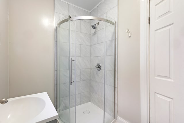 bathroom with sink and a shower with shower door