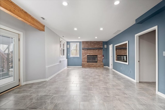 unfurnished living room with brick wall, a fireplace, and tile patterned flooring