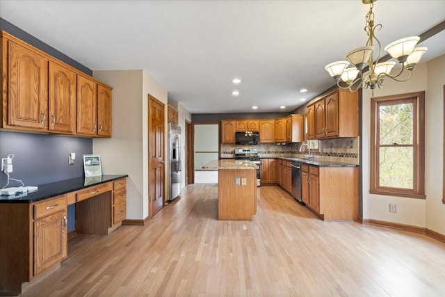 kitchen featuring a notable chandelier, light hardwood / wood-style flooring, a center island, stainless steel appliances, and pendant lighting