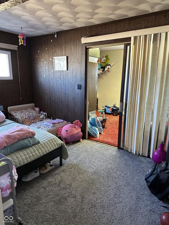 bedroom featuring carpet floors and wood walls