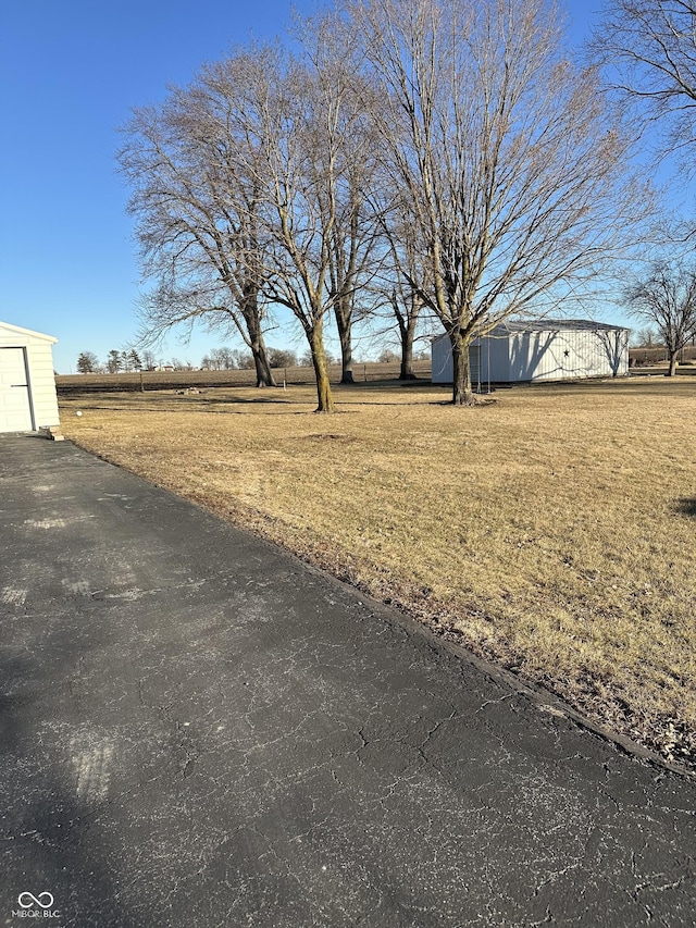 view of yard with a rural view and an outdoor structure