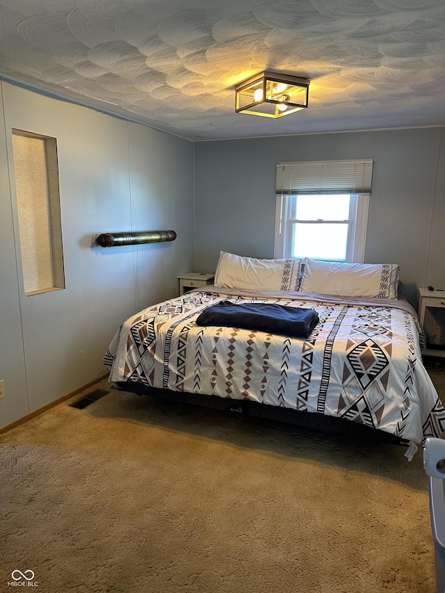 carpeted bedroom with visible vents and a textured ceiling