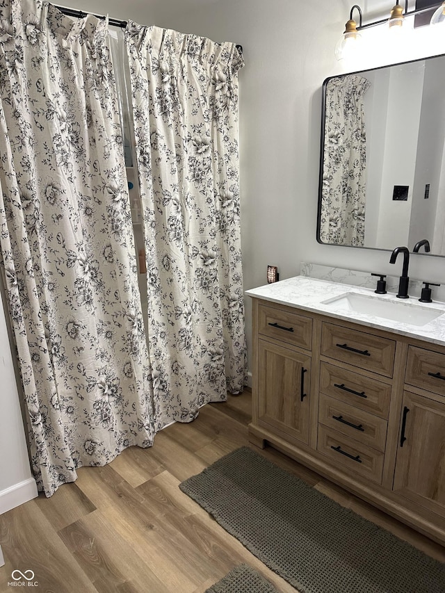 full bathroom with vanity and wood finished floors