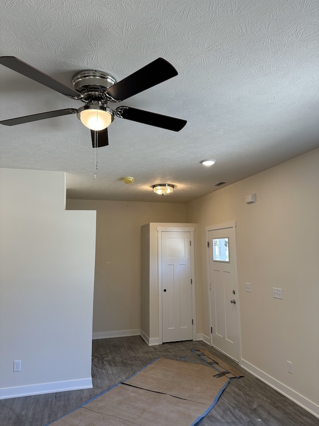 entryway with a textured ceiling, dark wood-type flooring, and ceiling fan