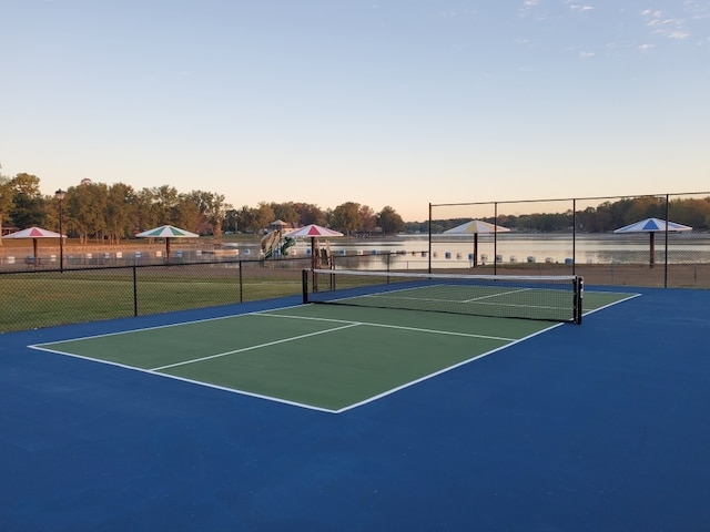 view of tennis court featuring a water view