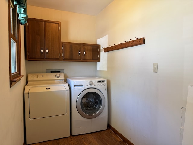 laundry room with dark wood-type flooring, washer and dryer, and cabinets