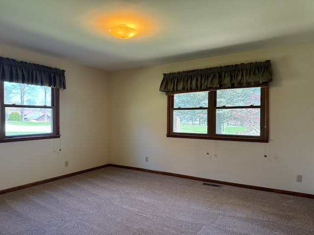 empty room with a healthy amount of sunlight and carpet