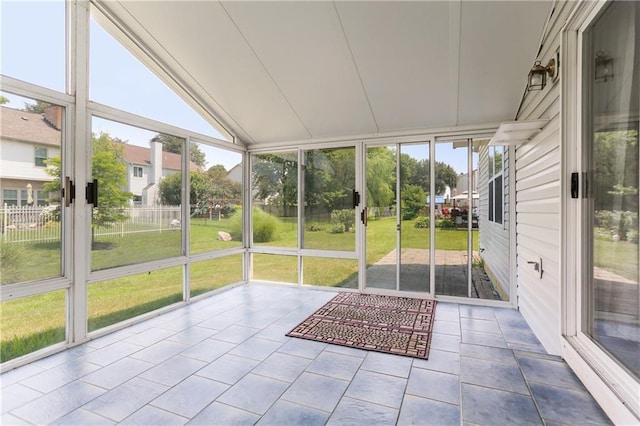 unfurnished sunroom with vaulted ceiling and a healthy amount of sunlight