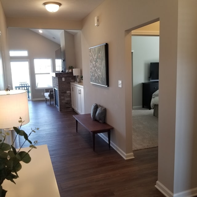 corridor with dark hardwood / wood-style floors and lofted ceiling