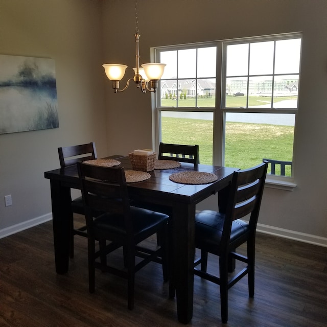 dining room with dark wood-type flooring and a chandelier