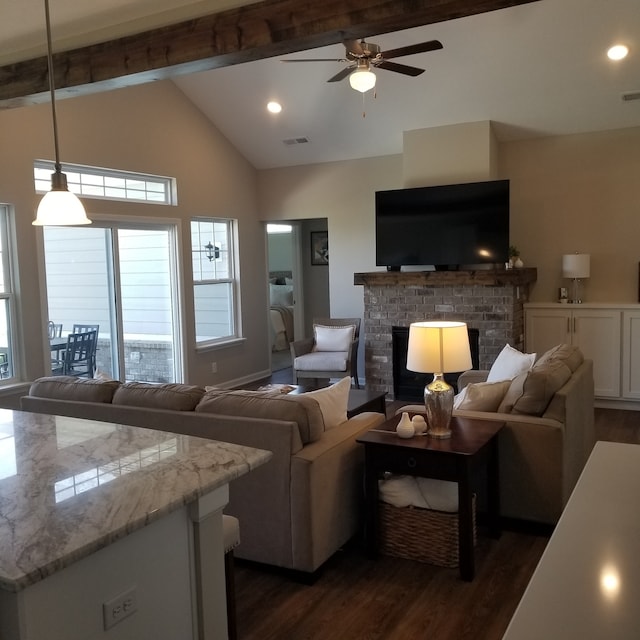 living room with lofted ceiling with beams, ceiling fan, dark hardwood / wood-style floors, and a fireplace