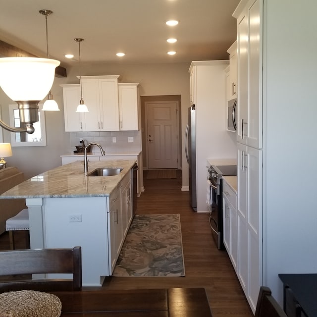 kitchen with hanging light fixtures, backsplash, stainless steel appliances, dark wood-type flooring, and sink