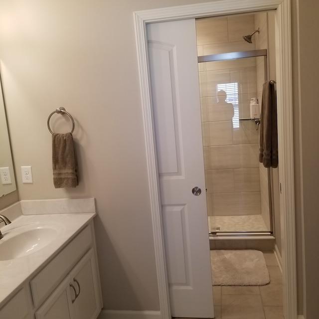 bathroom featuring an enclosed shower, tile floors, and vanity